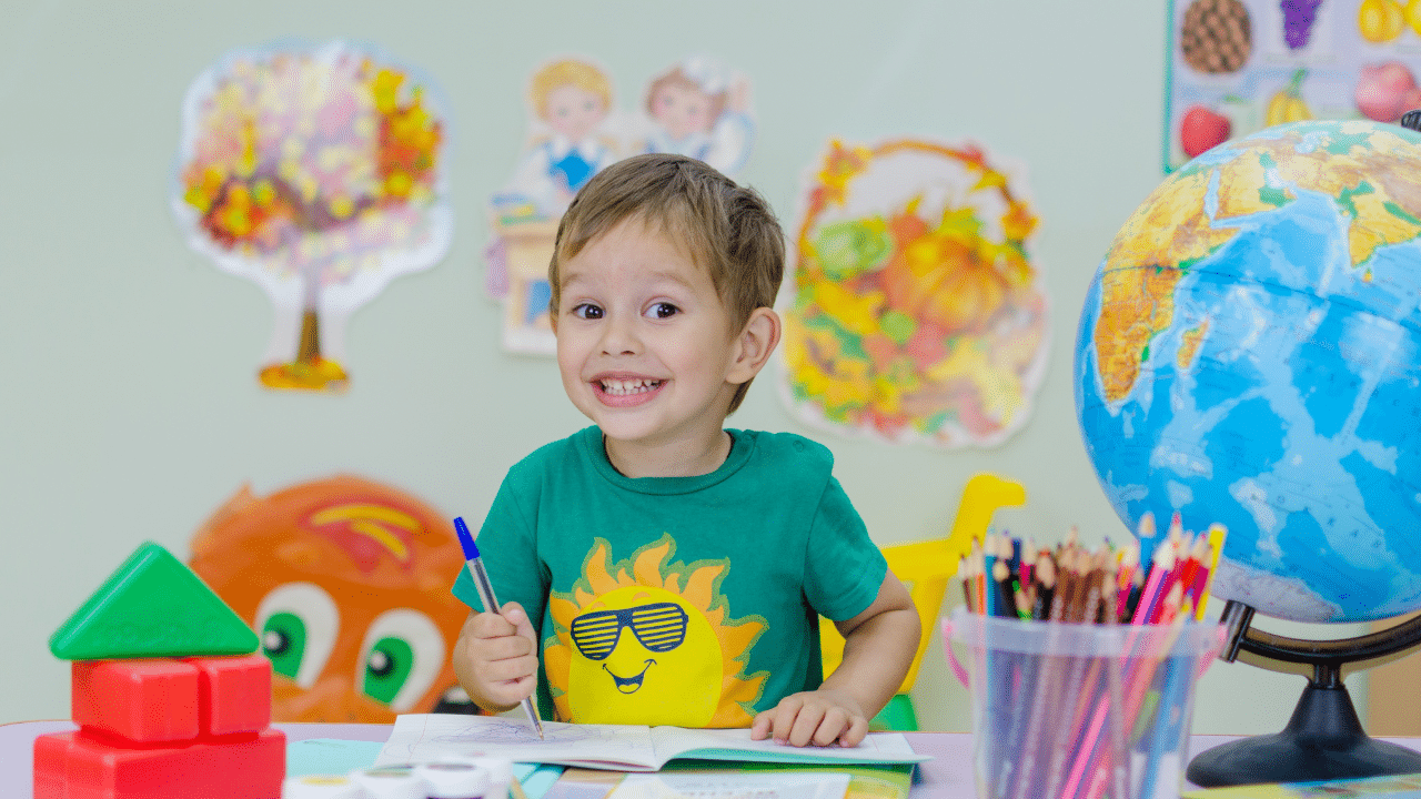 child surrounded by globe, penciles and other classroom supplies is grateful for free school supplies in charlotte NC