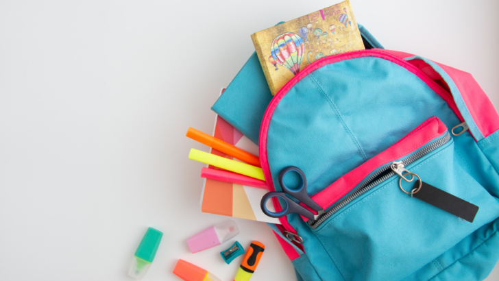 blue and pink backpack on white background spills free school supplies like erasers and pencils