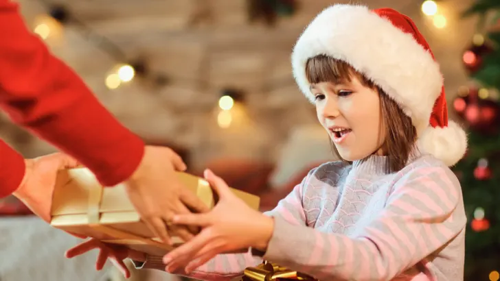 child receives presents after parents apply for free Christmas gifts in Colorado