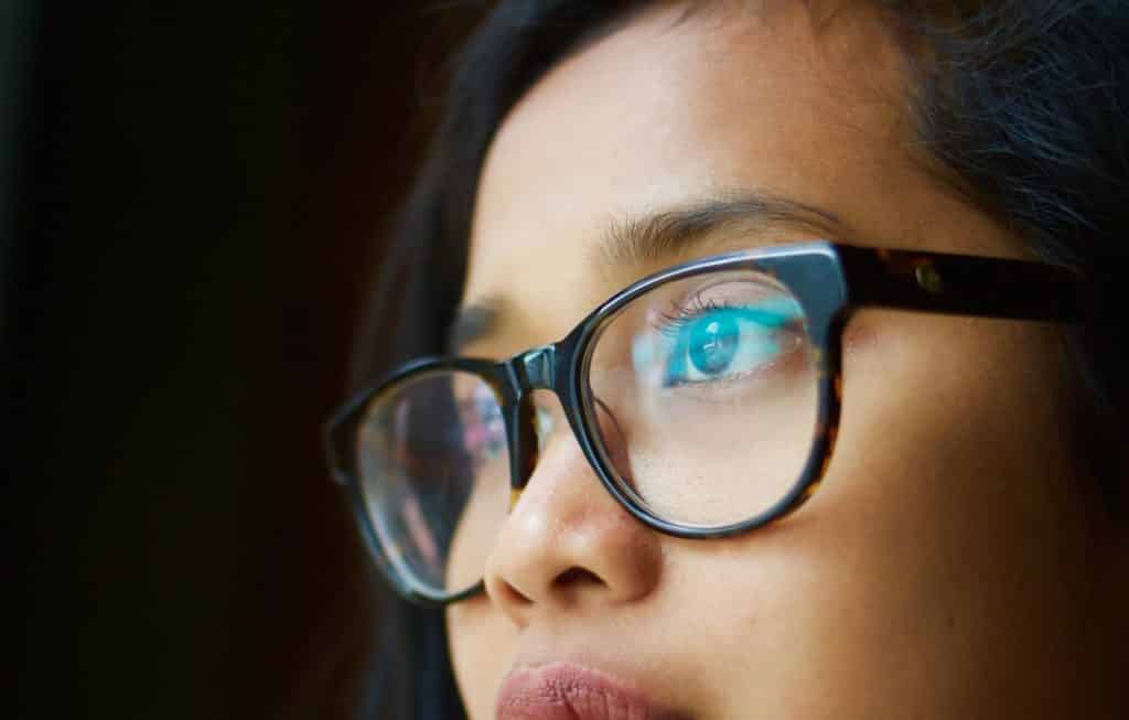 woman looks through cheap eyeglasses