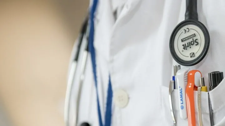 close up image of a doctor's chest with stethoscope and white coat with pocket full of pens in article on free clinics near me