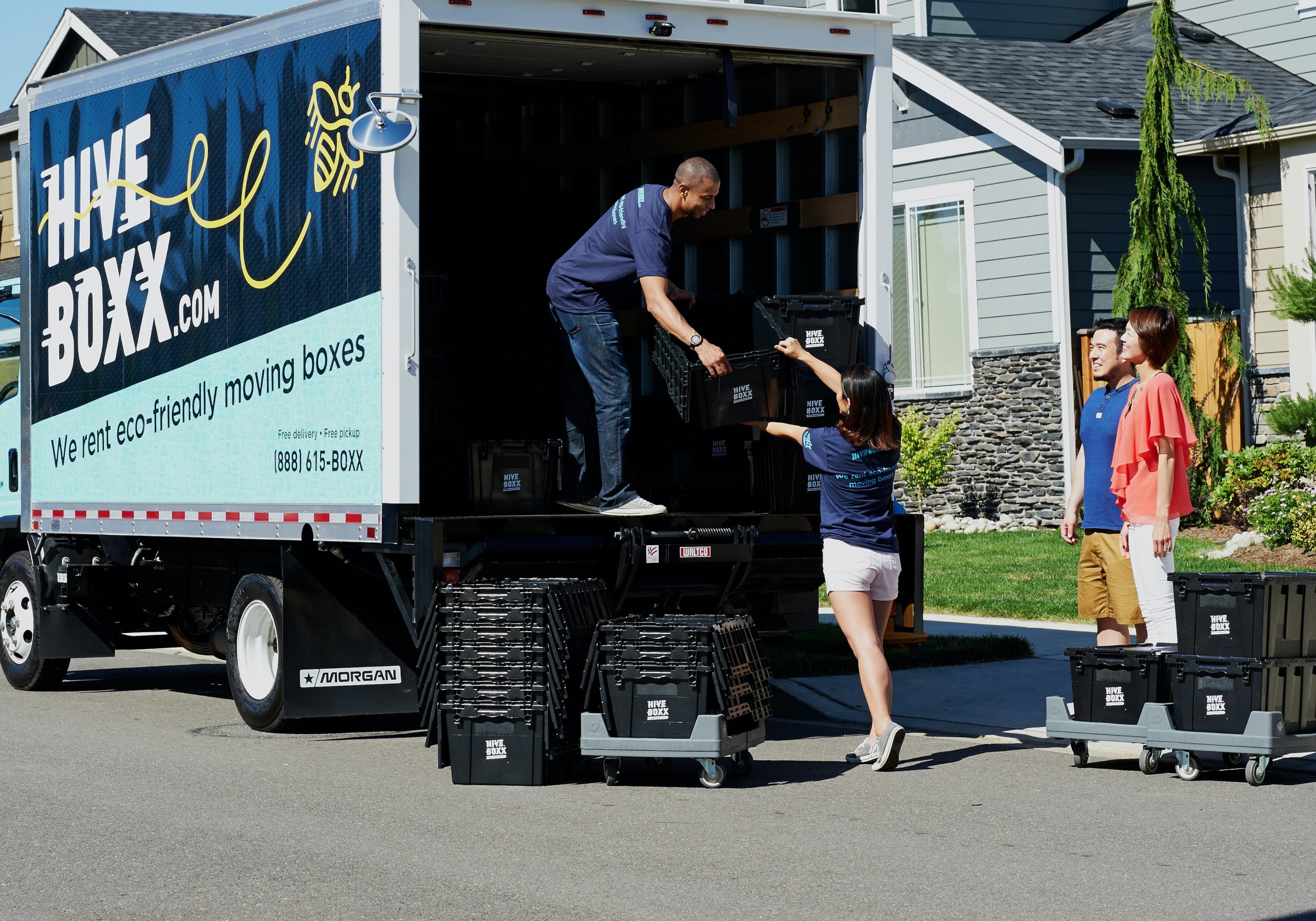 family standing in front of a new house, unloading a moving van in article about how to find free housing.