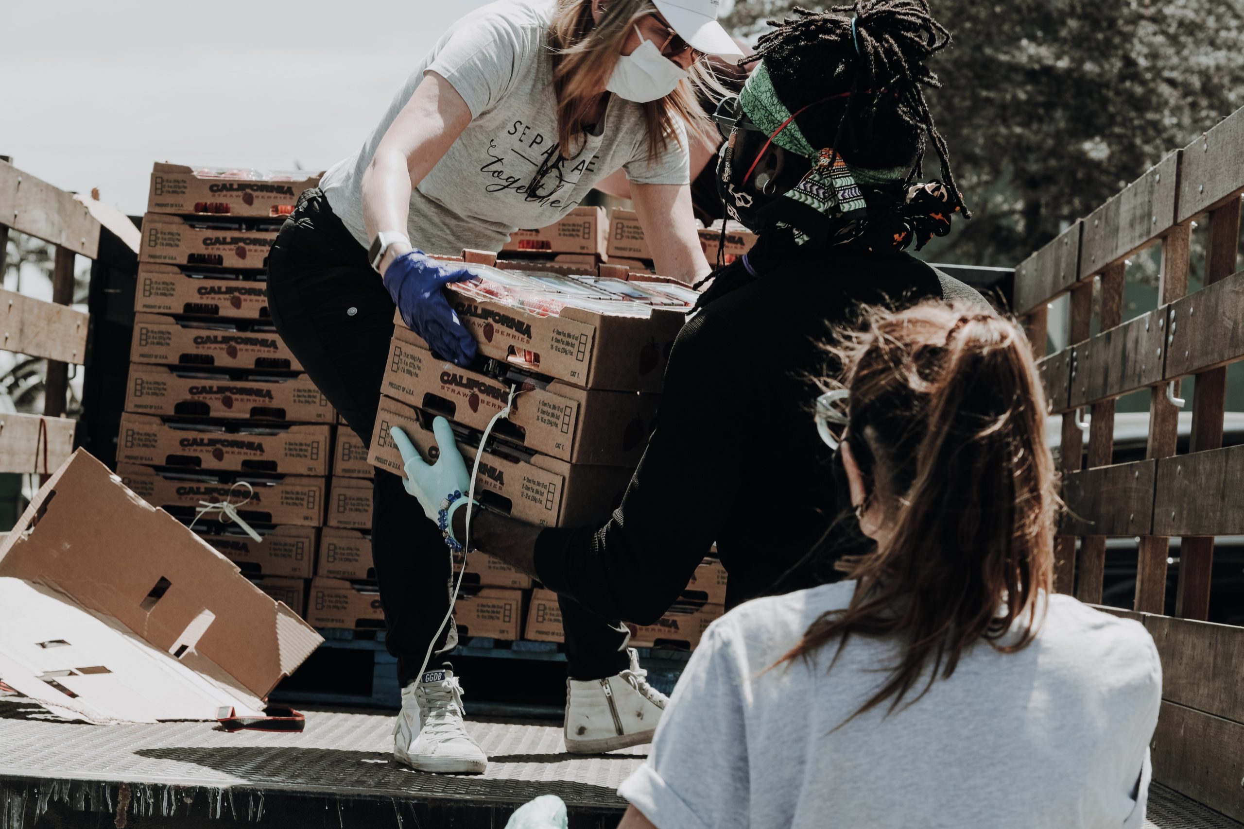 volunteers taking pallets food off a truck for a food pantry