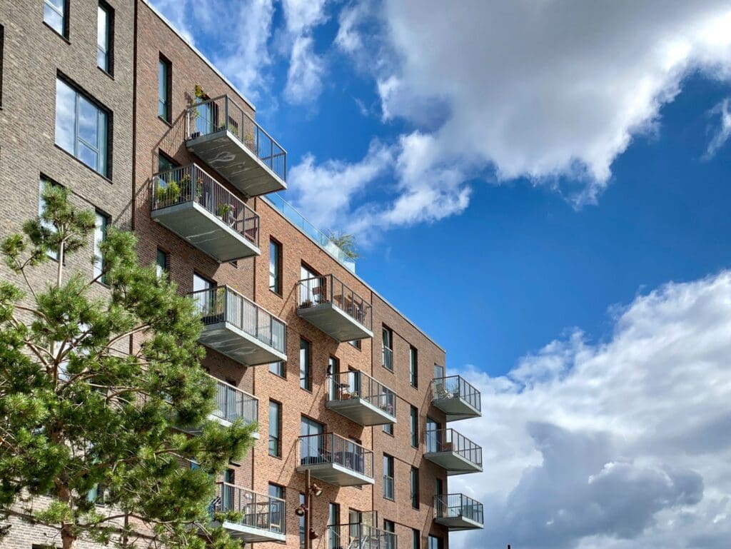 apartment building set against a blue sky in article about what is the most a landlord can charge for a security deposit?