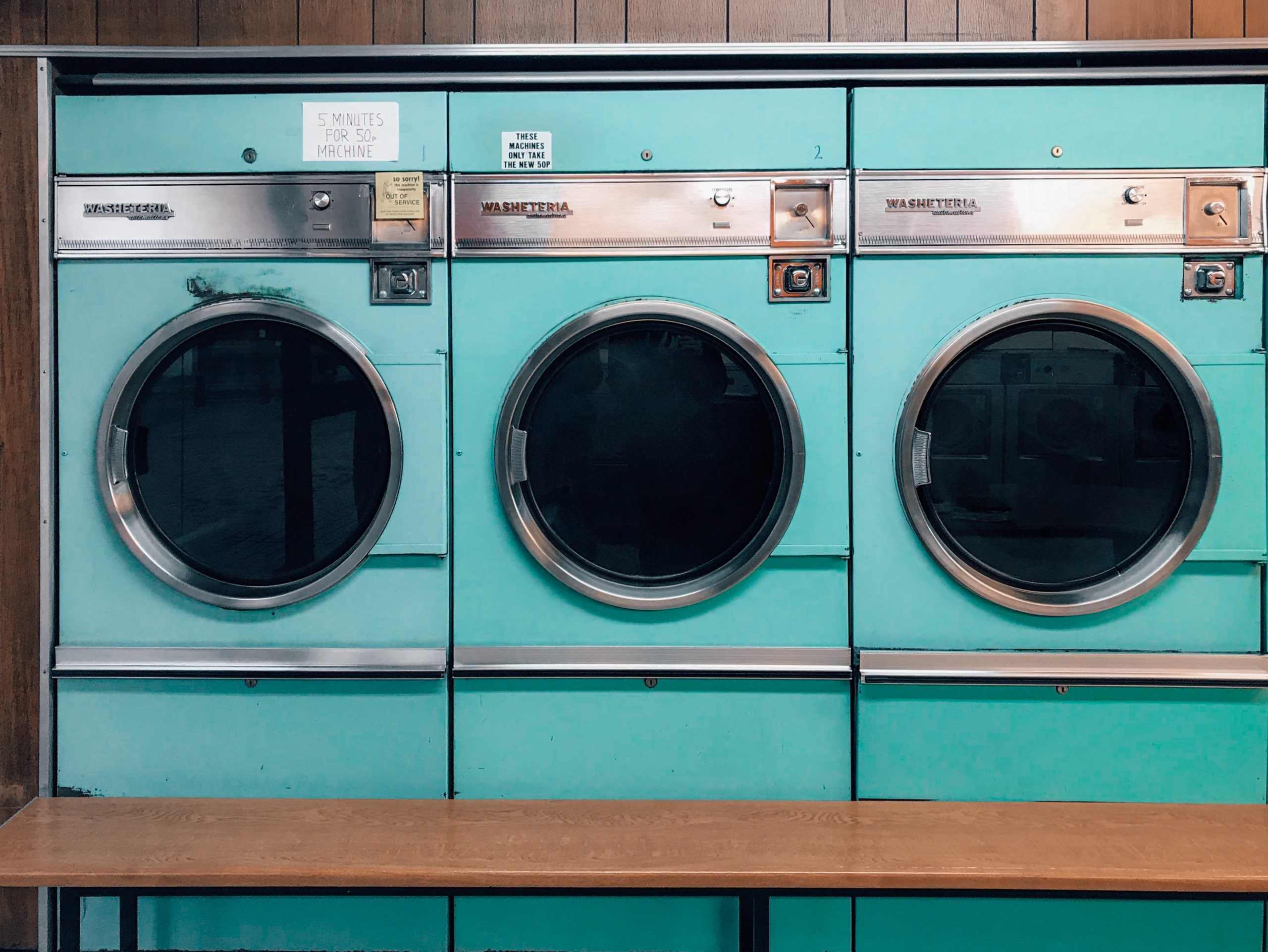 three aqua blue washing machines in a laundromat in article on how to use ebt cash benefits
