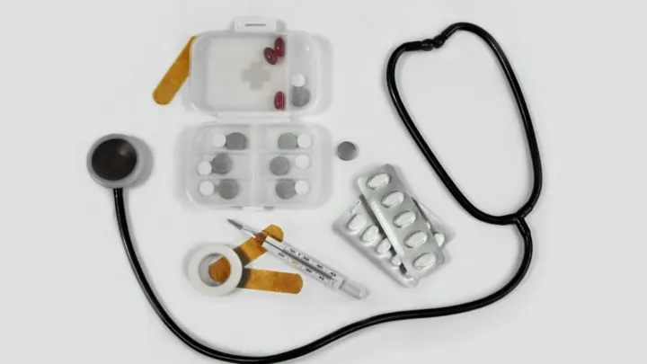 medical supplies including stethoscope, bandaids, and pills against a white background in article on medical help for immigrants
