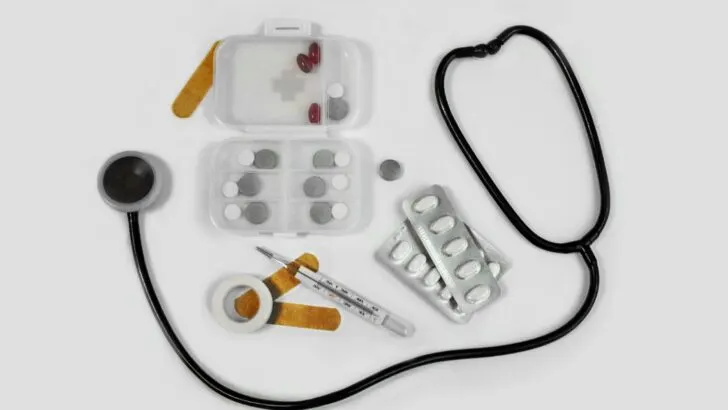 medical supplies including stethoscope, bandaids, and pills against a white background in article on medical help for immigrants