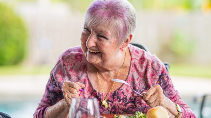 senior citizen woman eating a meal in article about how can adult protective services help