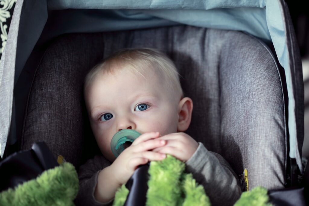 By Unsplash user Sharon McCutcheon. A blond baby sits in a car seat after his parent contacted Good News Garage to do a car seat installation.