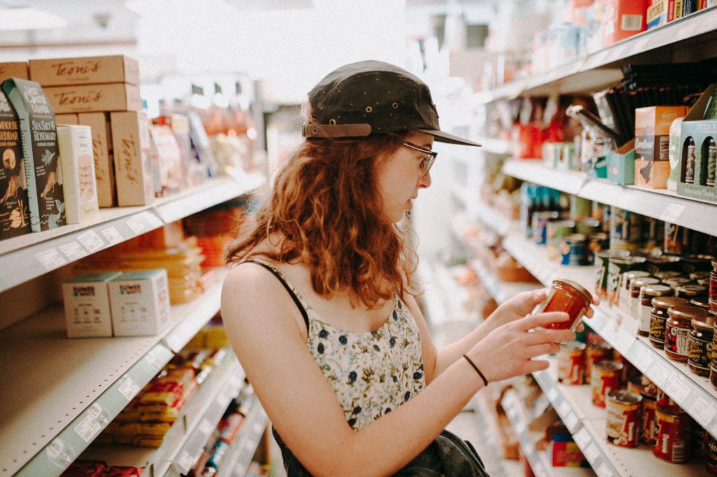 woman selecting groceries in article on can you use coupons with food stamps?