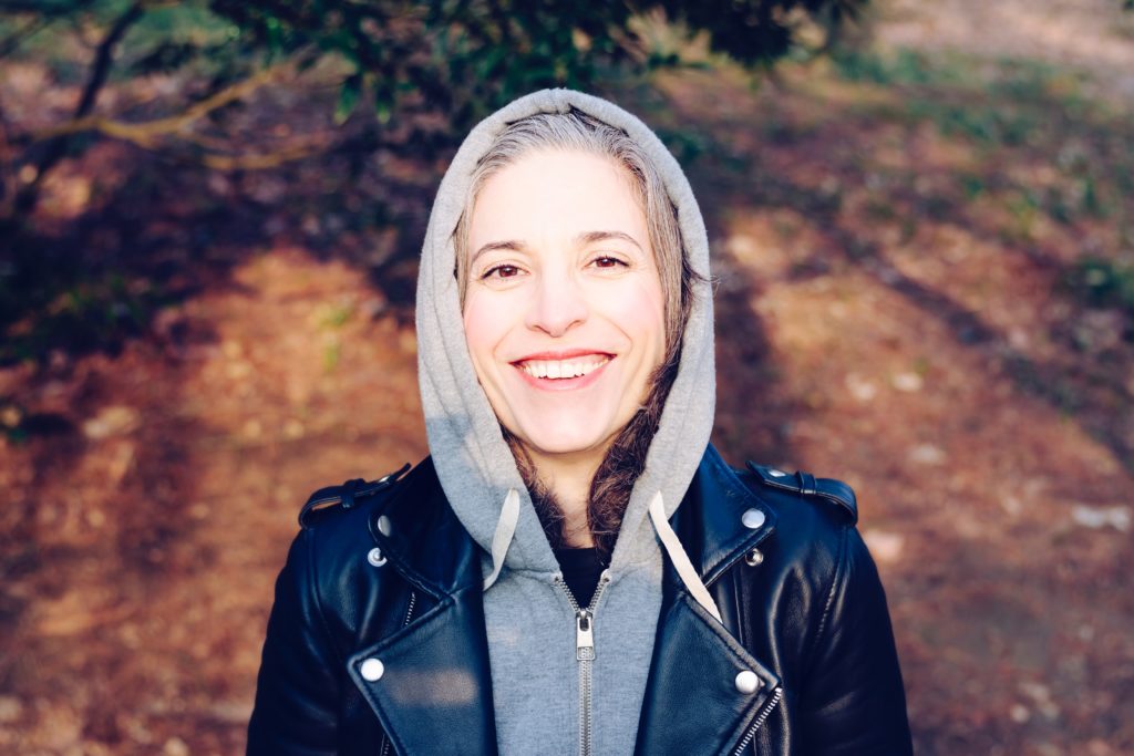 woman standing outdoors in a hoodie in article on how to get help with VA benefits