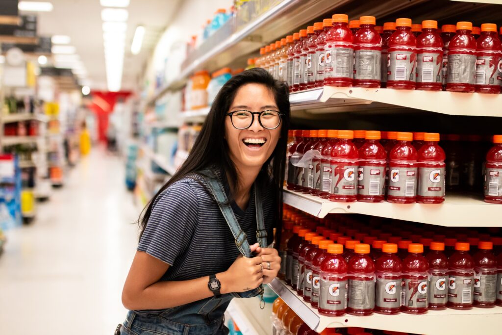 woman smiling in supermarket by juice display in article on can i use my ebt card in other states