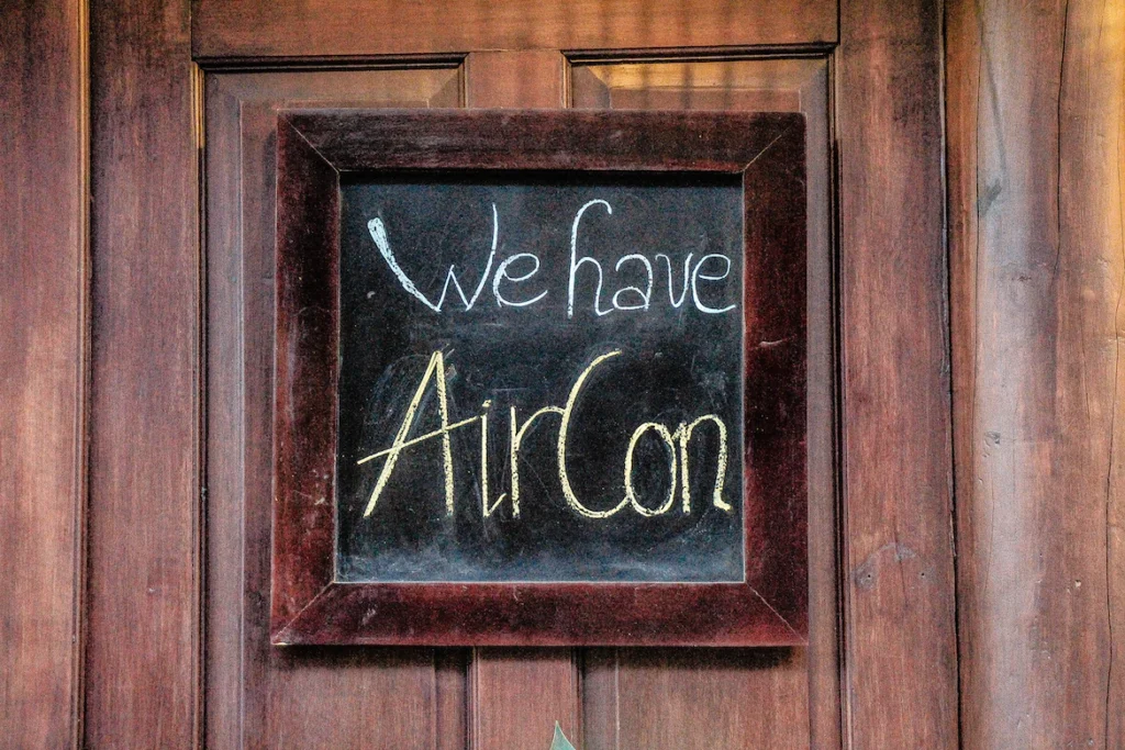 If your landlord won't fix the heat or A/C, we're here to help. A picture of a blackboard sign that says "We Have Air Conditioning" written in chalk. By Unsplash user René DeAnda.