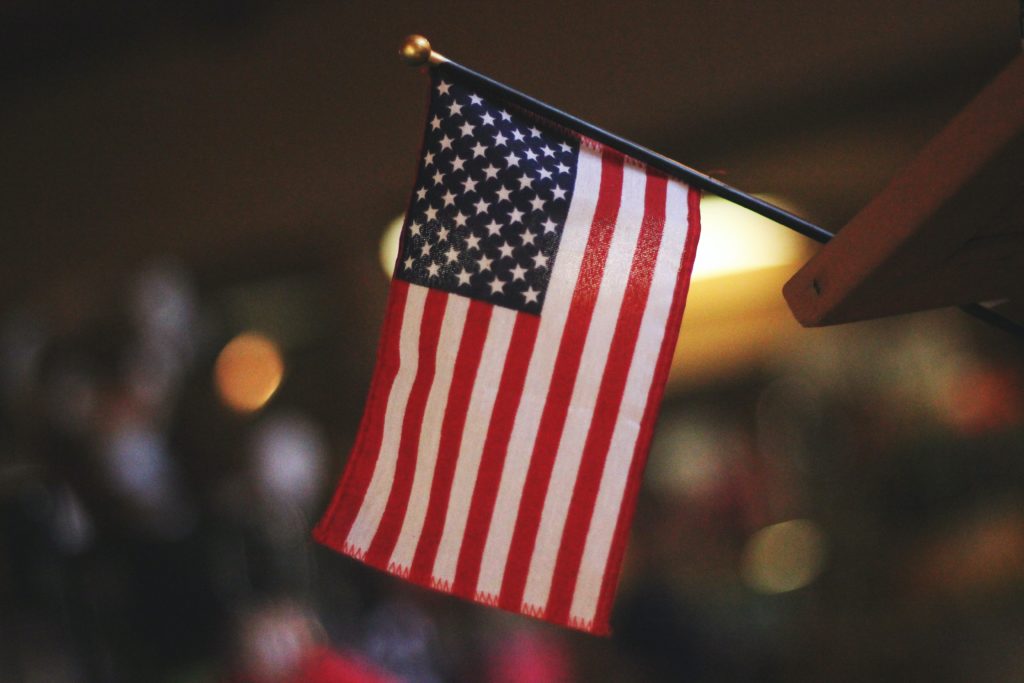 hand holding flag in article on What States Have the Best Benefits for 100% Disabled Veterans