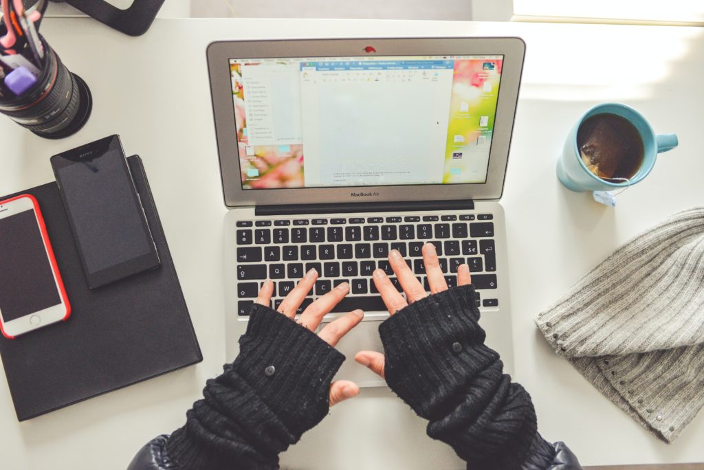 woman in fingerless gloves typing on laptop in article on i have no credit score