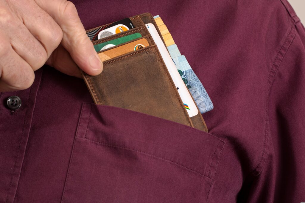 Man pulling his wallet out of his shirt pocket.