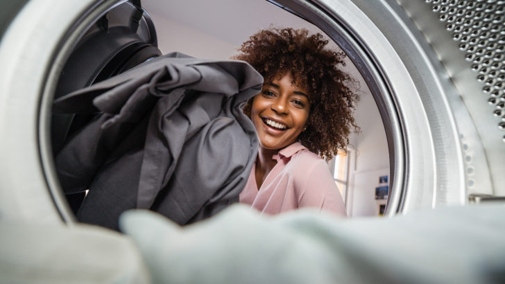 woman loads laundry machines at a free dry laundromat