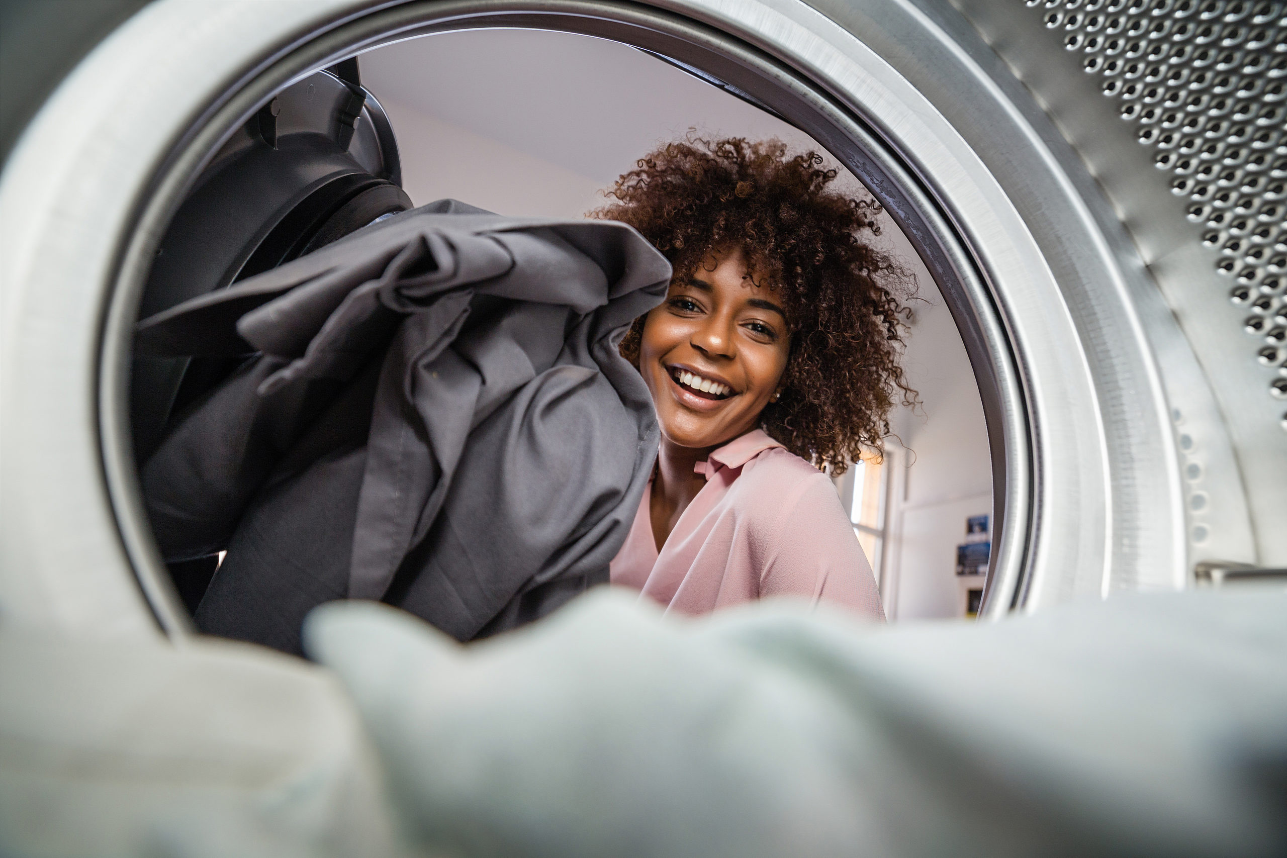 woman loads laundry machines at a free dry laundromat