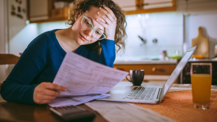 worried woman looks at her electricity bill in Oregon
