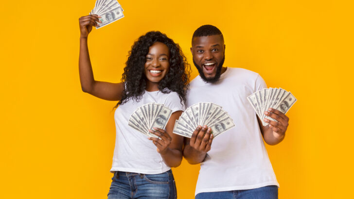 couple holds money after winning their guaranteed income application