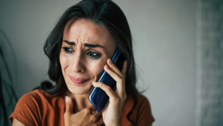 woman cries on phone waiting for states to replace EBT benefits
