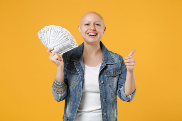 breast cancer patient holds cash from the pink fund financial assistance program