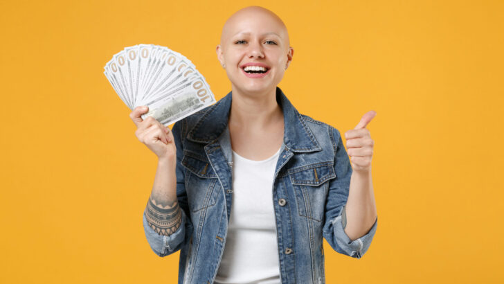 a woman holding money and giving thumbs up