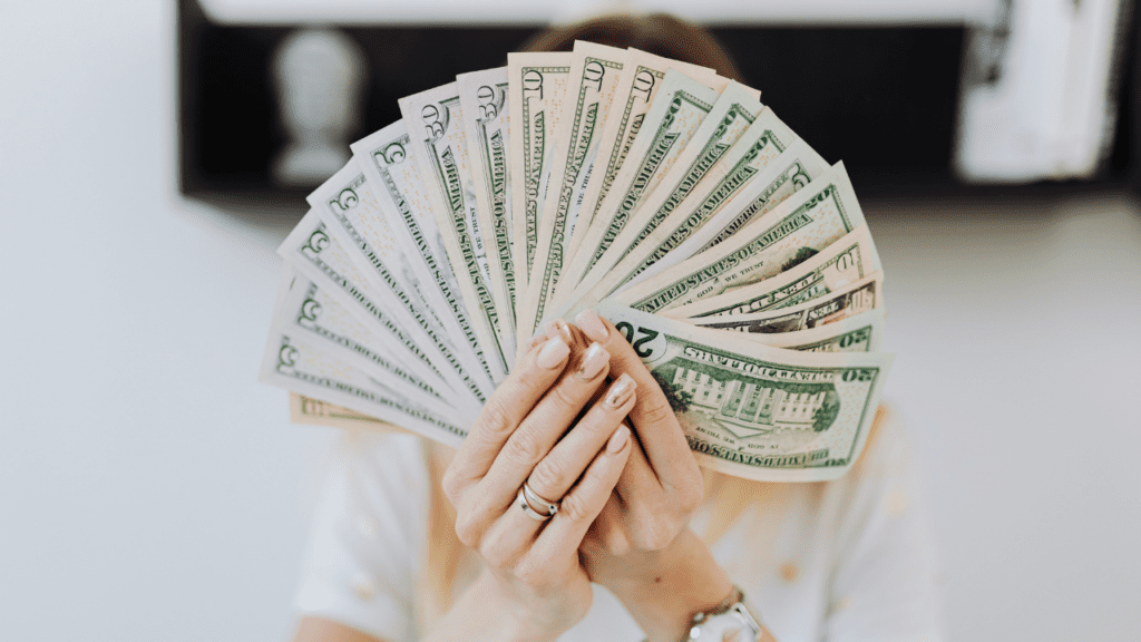 a woman holding a fan of money