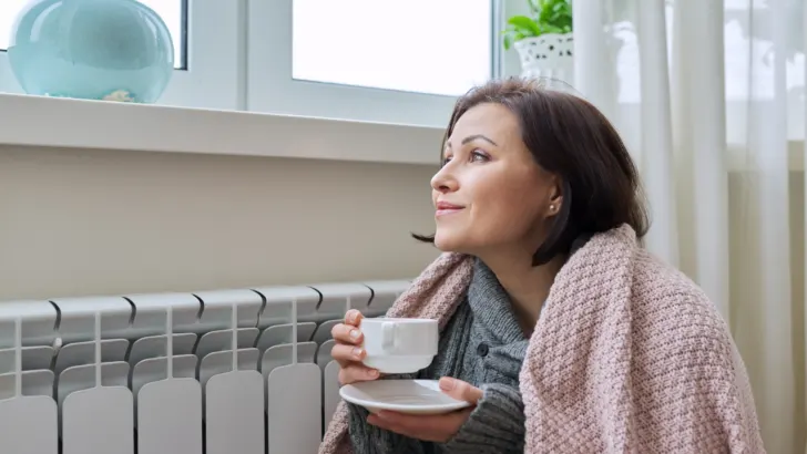 woman enjoys warmth from a free space heater