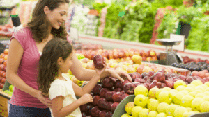 woman and child buy fruit with extra ebt benefits from eat well be well program in rhode island