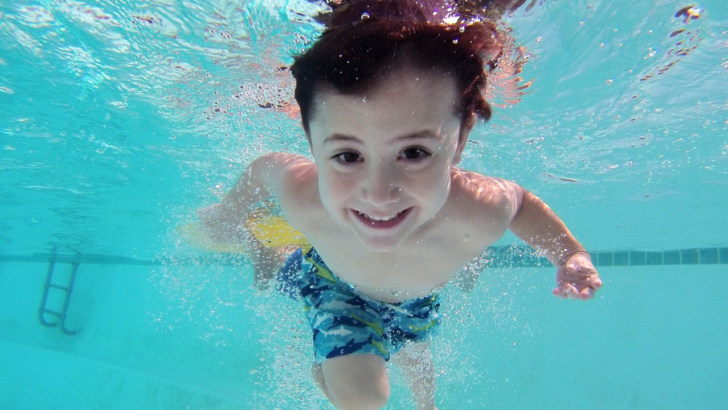 child swims underwater during free swimming lessons for low income families