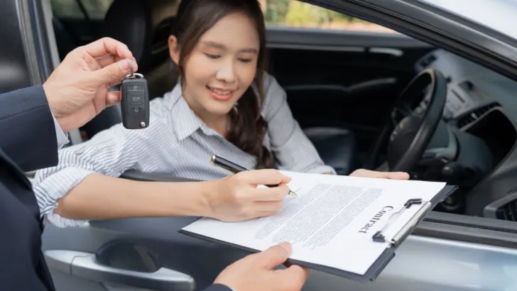 woman signs contract on low income auto loans