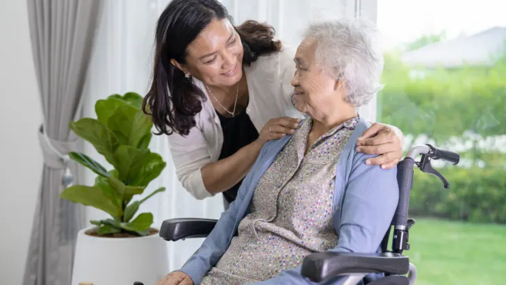 woman cares for grandma in wheelchair through medicaid caregiver program