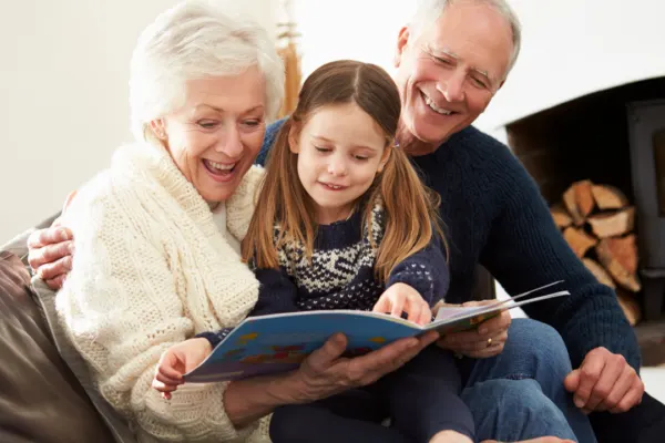 two foster grandparents read a book with a child who needed extra literacy support