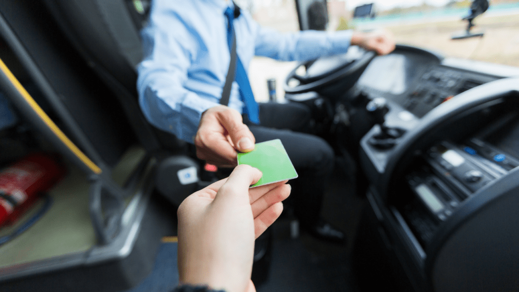 person hands a bus driver a free bus ticket home