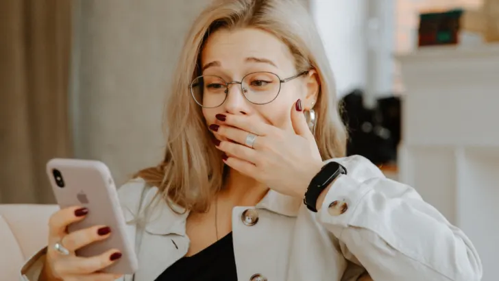 woman puts hand over mouth while looking at phone in surprise about how to get free stuff for medicaid