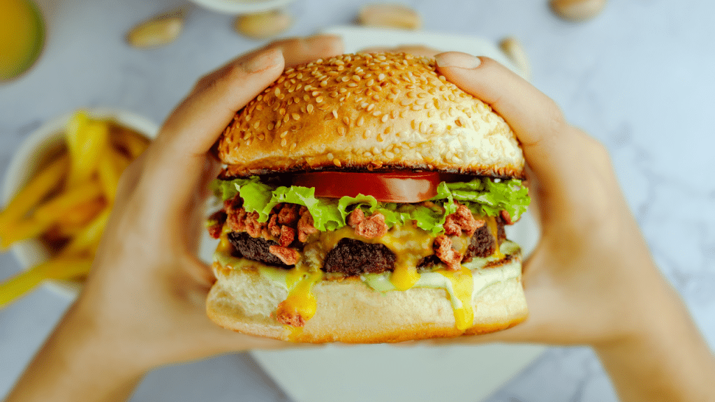 someone eats a burger from restaurants accept EBT in San Diego