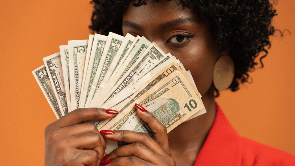woman holds cash fan while discussing low income relief's January cash guide