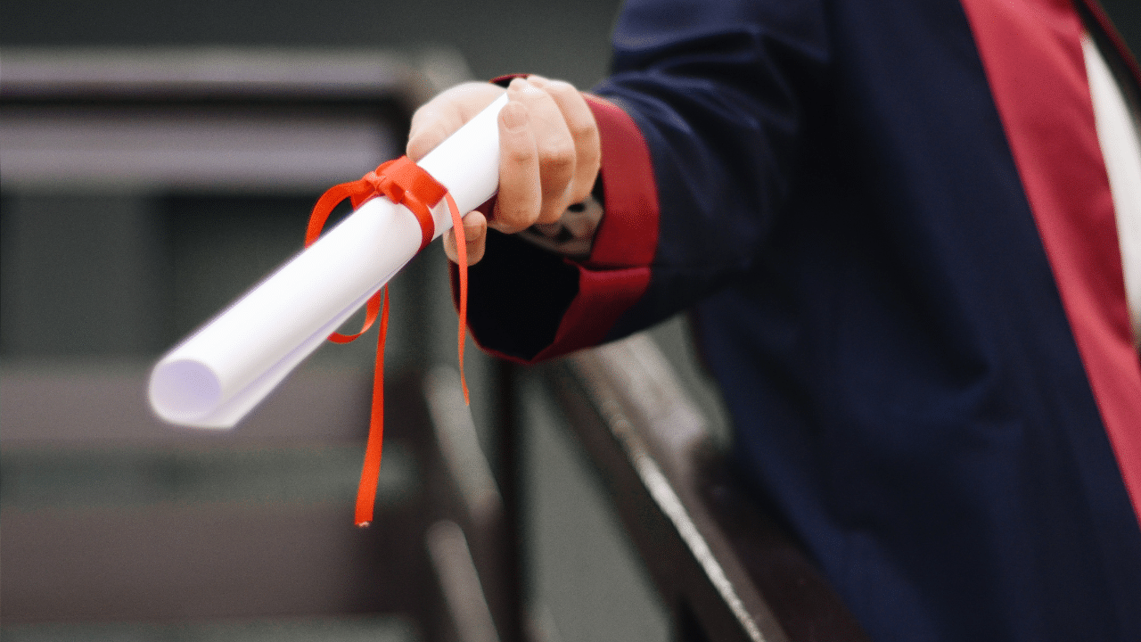 graduate is handed a degree after attending one of the colleges that offer free tuition for low income families