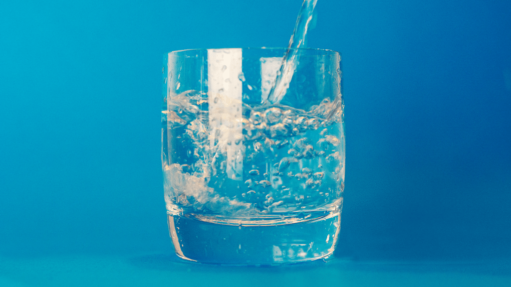 water in a cup on a blue background represents free well water testing kits available in lincoln county