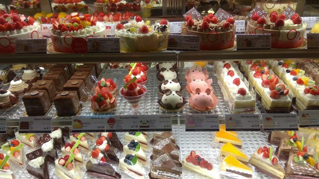 An enticing display of various cakes and desserts in a bakery shop, perfect for sweet indulgence.