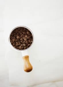 A minimalist shot of chocolate chips in a measuring cup, ideal for baking concepts.