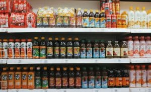Vibrant rows of assorted drinks on a supermarket shelf, showcasing variety.