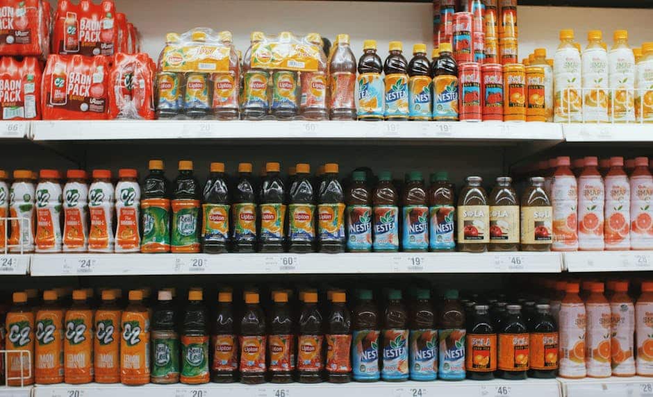 Vibrant rows of assorted drinks on a supermarket shelf, showcasing variety.